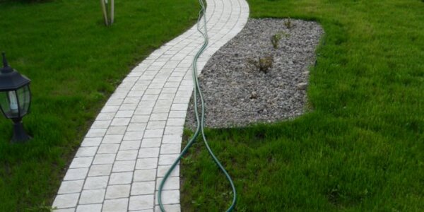 Мощение дорожки в виде змейки. Газонная трава только начинает развивать корневую систему